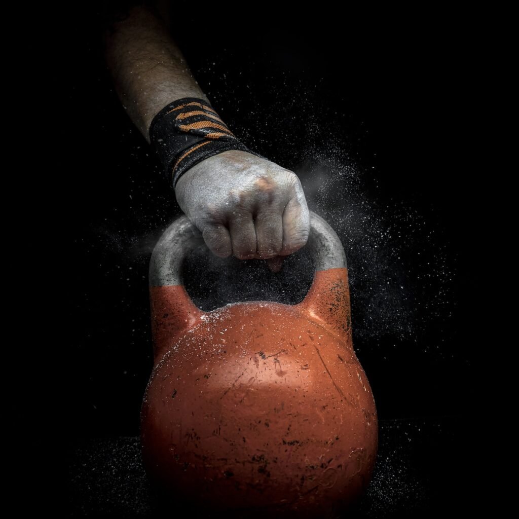 A fit man holding a kettlebell, demonstrating proper form for kettlebell training