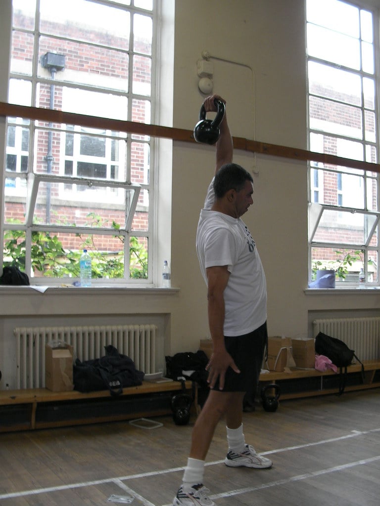 Three basic kettlebell holds: Standard Hold with the weight resting on the forearm, Hook Grip allowing for a rotating handle, and Bottoms-Up Grip balancing the kettlebell upside-down on a clenched fist