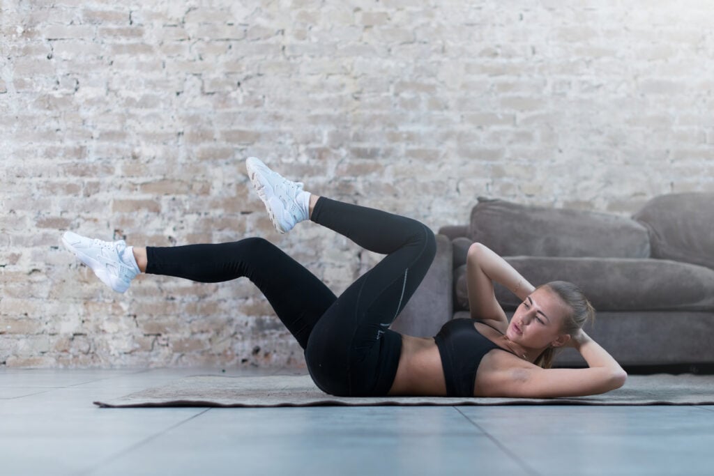 Fit woman demonstrating proper form for oblique crunches to strengthen and tone core muscles.