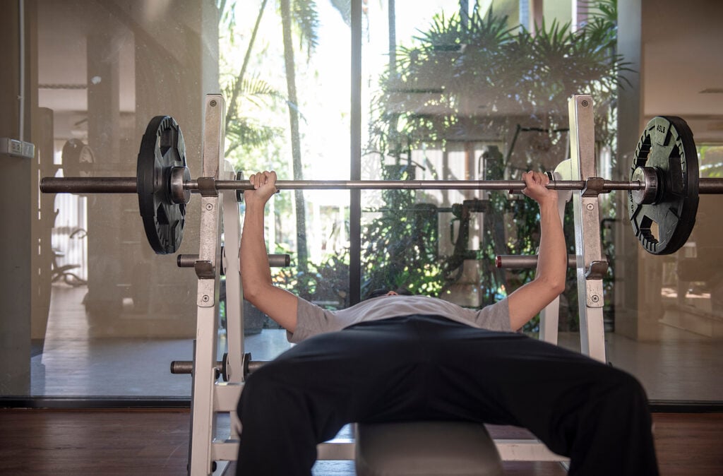 Man performing Wide Grip Bench Press for chest workout