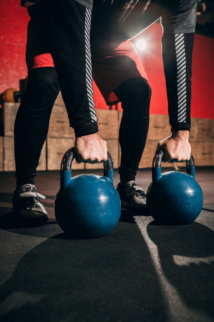 Person demonstrating the Hook Grip on a kettlebell, holding the handle loosely to allow for a fluid and controlled swing.