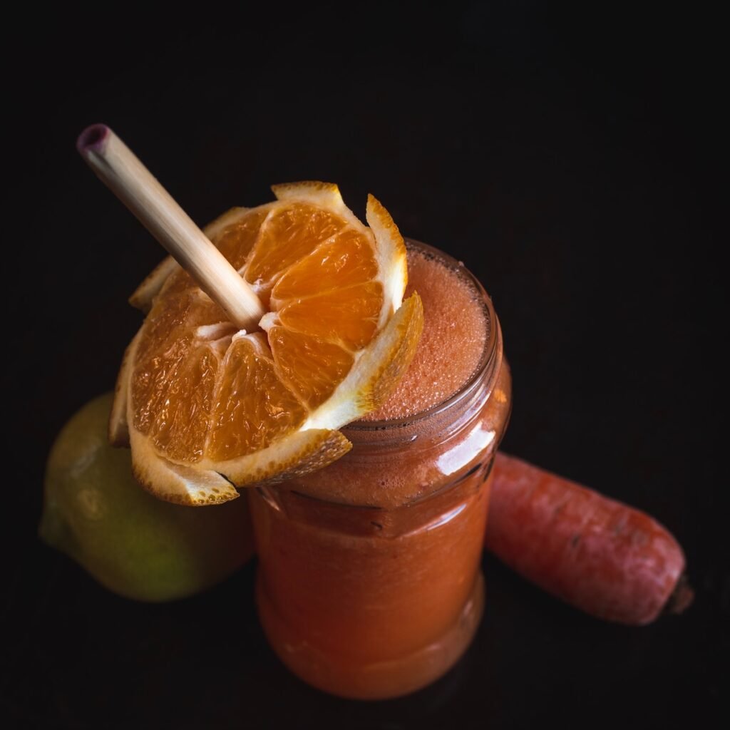 A vibrant weight loss smoothie with an orange slice garnish, served in a glass jar.