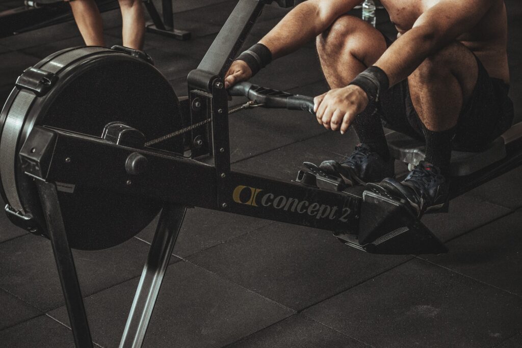 A fitness enthusiast fully engaged in a cardio rowing workout, demonstrating proper technique and form.