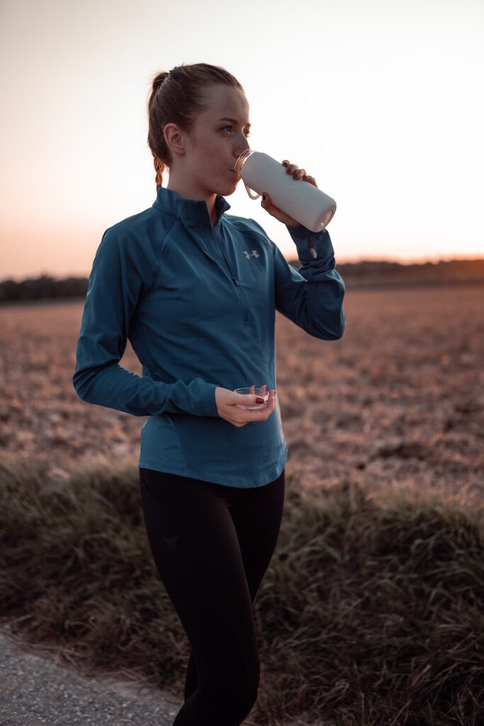 Runner Hydrating with a Cup of Water in Sportswear