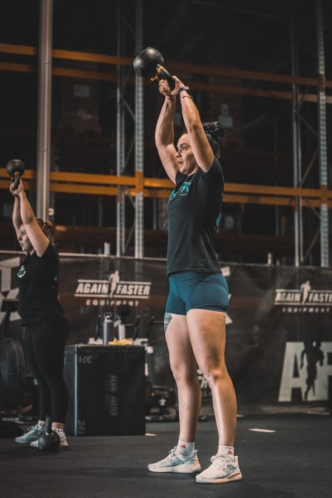 Person demonstrating the Bottoms-Up Grip, holding the kettlebell upside-down and balancing the weight on a clenched fist for optimal stability.