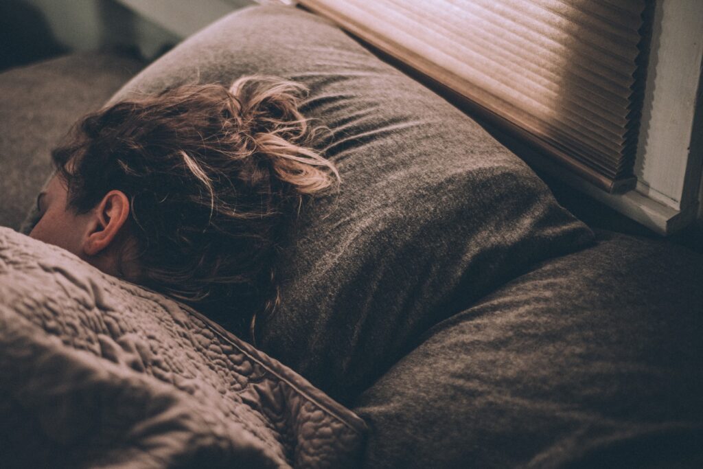 Woman sleeping peacefully, illustrating the importance of sleep for muscle recovery.