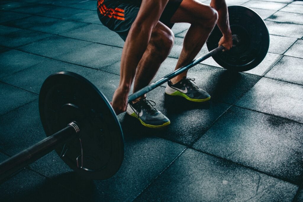 Man executing a deadlift with impeccable form, activating multiple muscle groups from his legs to his back.